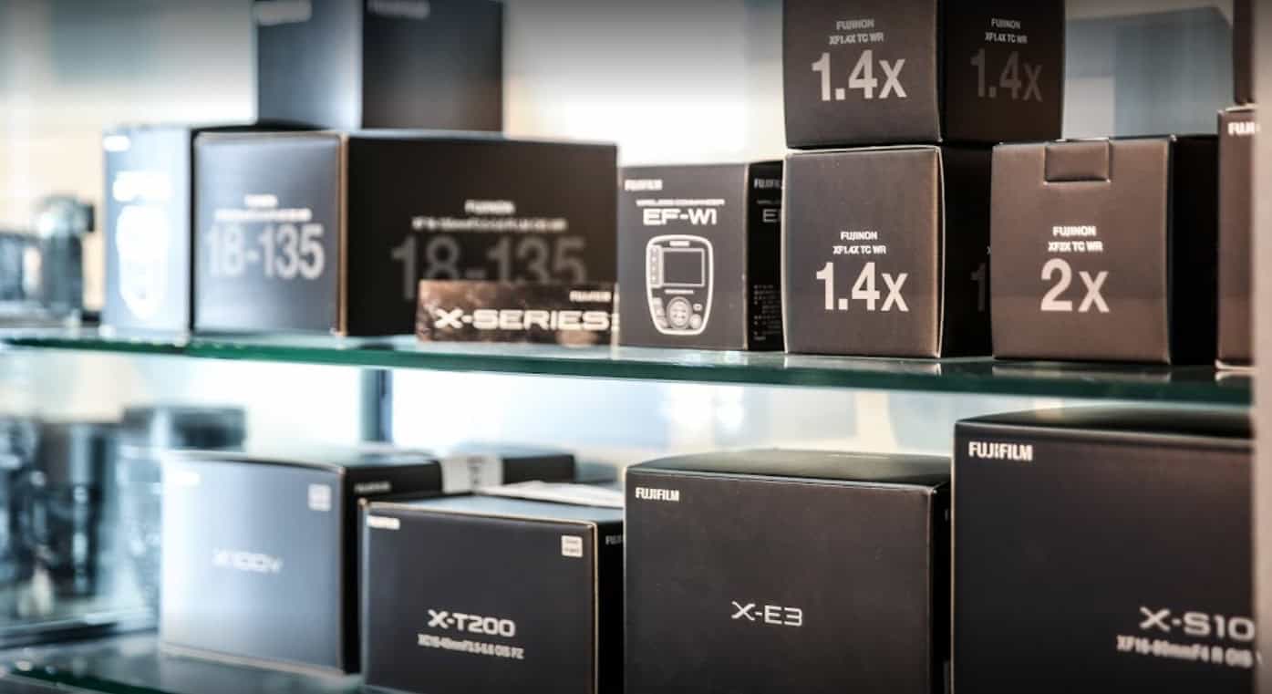 Verschiedene Kameraobjektive und Zubehör in der X-Kamera Verkaufsregal.
